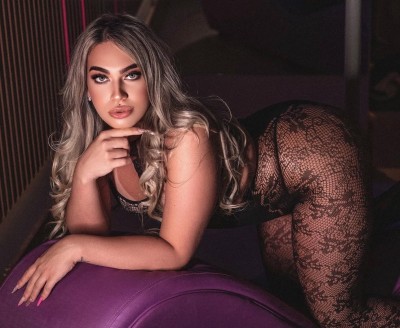 Trans, feminina, loira, olhos verdes, tatuada...